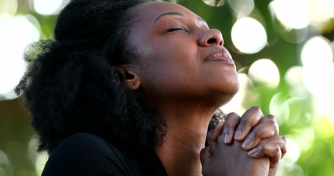 African woman feeling hopeful and spiritual. Faithful person having HOPE and FAITH