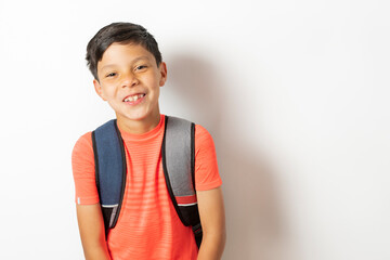 Boy showing his smile holding his school bag ready for the start of school. Back to school concept