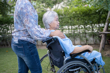 Doctor help and care Asian senior or elderly old lady woman patient sitting on wheelchair at park in nursing hospital ward, healthy strong medical concept.