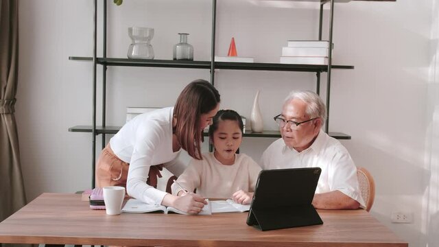 Middle-aged male and daughter helping granddaughter with school activities
