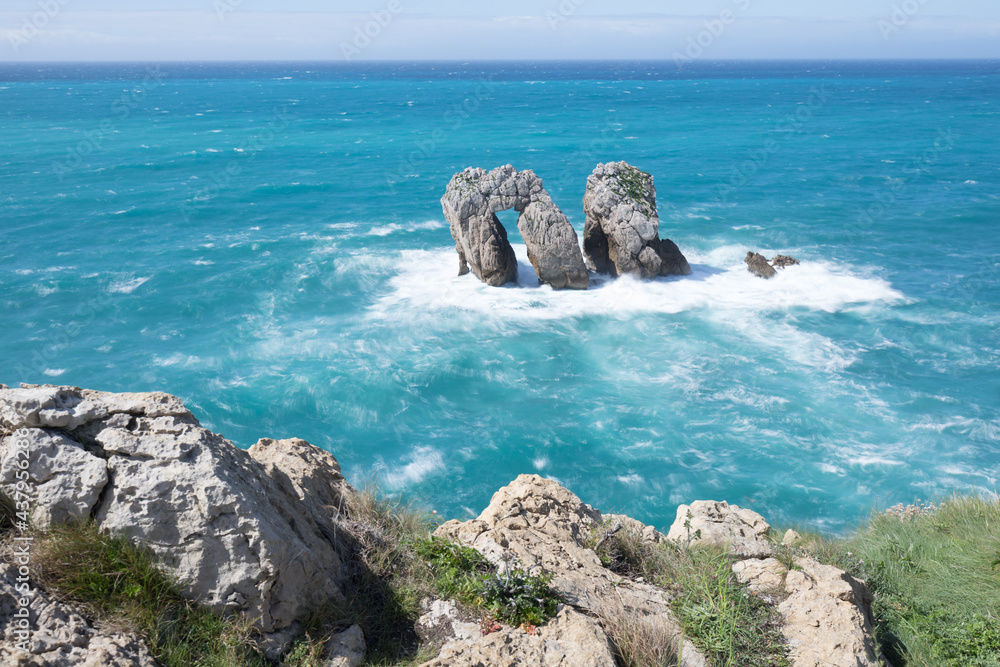 Wall mural Sea view with cliffs landscape on north Spain. Atlantic Ocean coast. Beautiful sunny day. 
Scenic golden cliffs and emerald water during holiday season.