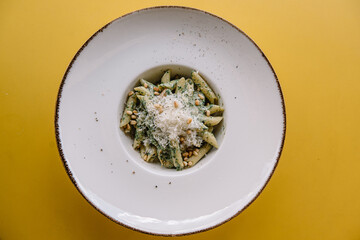 Italian pasta with pine nuts and a lot of parmesan cheese on a plate.