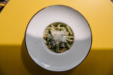 Italian pasta with pine nuts and a lot of parmesan cheese on a plate.