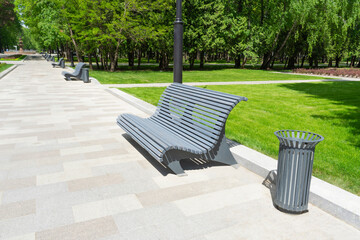 Summer park, urban environment design. A bench and a trash can.