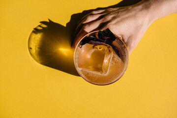 glass of basil smash cocktail on yellow table