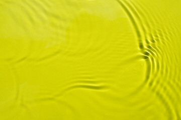 Water spills on a light green yellow background. Natural sunlight and shade. Beautiful glare. Summer mood. Minimal style.