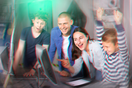 Happy interested family with teen sons trying to get out of closed space of escape room stylized as abandoned bunker, using computer. Toned image with color visuals..