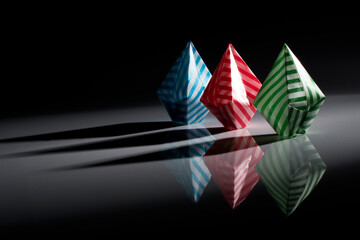 Origami balloons made of colored papers isolated on black background.