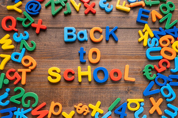 Colorful plastic word "Back To School" on wooden background