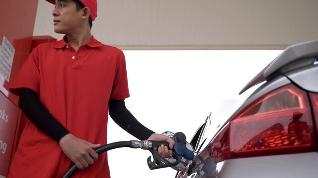 worker man hand holding Petrol Pumping Fuel oil at gas pump. man refuel the car at the petrol station. filling car with petrol at gas station. Pumping fuel in to the tank.