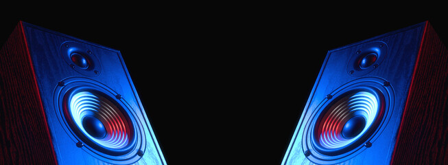 Two sound speakers in neon light with free space between them on black.