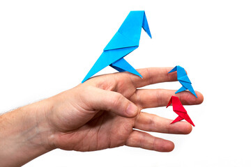 Hand holds an Origami bird made of colored paper isolated on white background