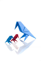 Origami bird made of colored paper isolated on white background. Family concept