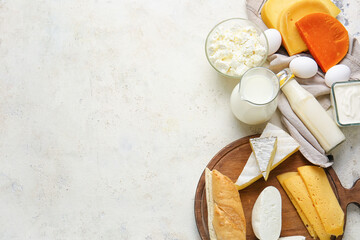 Different dairy products and chicken eggs on light background
