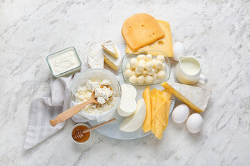 Different dairy products and chicken eggs on light background