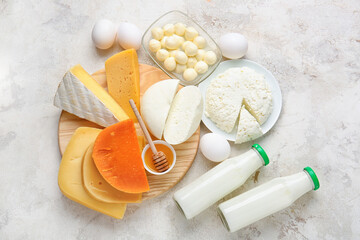 Different dairy products, chicken eggs and honey on light background