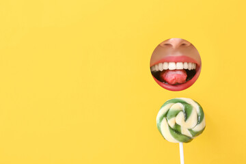 Sweet lollipop and mouth of young woman visible through hole in color paper