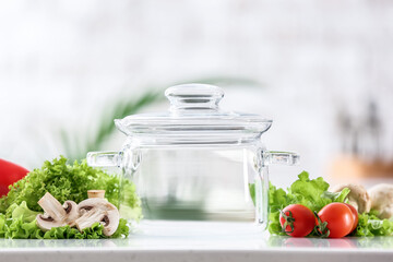 Stylish cooking pot and fresh vegetables on table in kitchen