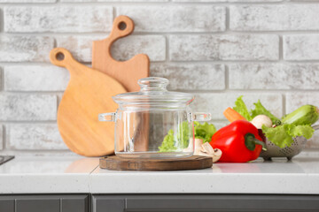 Stylish cooking pot and fresh vegetables on table in kitchen