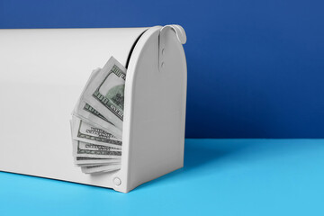 Mail box with money on color background