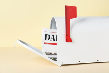 Mail box with newspaper on color background