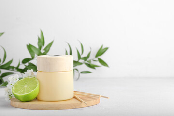 Reed diffuser with lime and flowers on light background