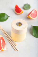 Reed diffuser with grapefruit on light background