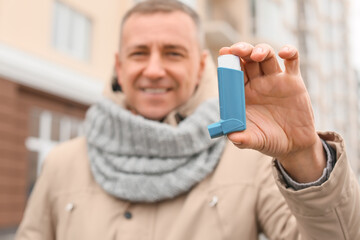 Senior man with inhaler outdoors, closeup