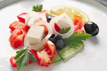 Plate of tasty Greek salad on table, closeup