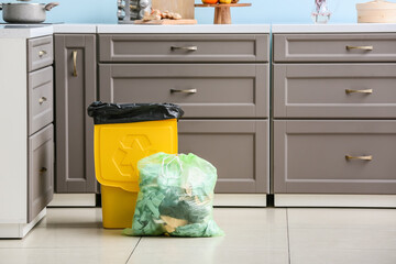Bag with garbage and rubbish bin with logo of recycling at home