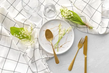  Beautiful table setting with lily-of-the-valley flowers on light background © Pixel-Shot