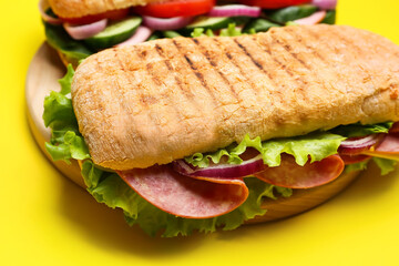 Board with tasty ciabatta sandwiches on color background, closeup