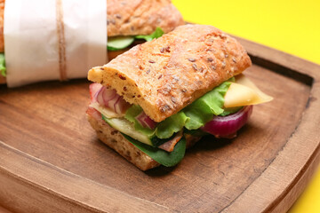 Board with tasty ciabatta sandwiches, closeup
