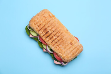 Tasty ciabatta sandwich on color background