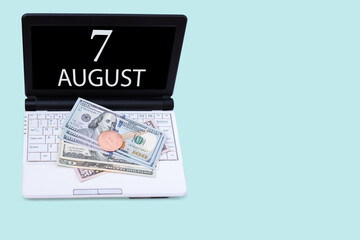 Laptop with the date of 7 august and cryptocurrency Bitcoin, dollars on a blue background. Buy or sell cryptocurrency. Stock market concept.