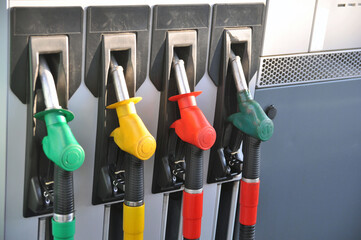 Fuel dispenser at a gas station. Hoses with dispensing guns.