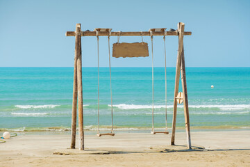 empty swing on the beach with sea view in summer day