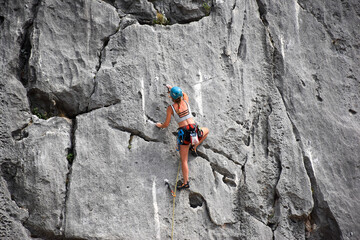 Beautiful girl climbing rock mountain