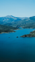 Fototapeta na wymiar Lago grande entre las montañas , embalse en la sierra , vista aérea del embalse, vista de la presa en la montaña