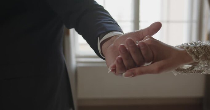 The groom with an outstretched hand. The bride takes the groom's hand