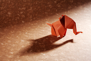 Fototapeta na wymiar Origami elephants isolated on craft paper background.