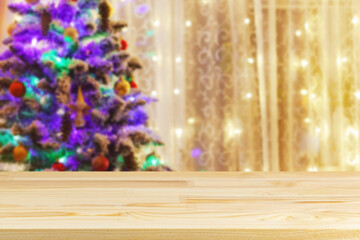 wood table top on blur christmas tree with garland background