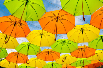 Nice yellow orange green and red color umbrella on blue sky