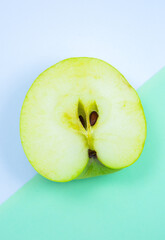 Close up photo of Green Apple Fruit on the white and green background. Minimalism, original and creative image. Beautiful natural wallpaper.
