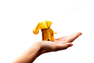 Hand holding a craft paper origami elephant isolated over a white background.