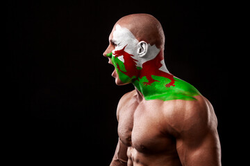 Wales fan. Soccer or football athlete with flag bodyart on face. Sport concept with copyspace.
