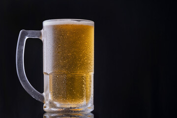 a mug of cold beer on black background