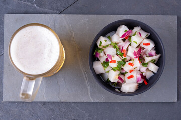a bowl of ceviche and a mug of cold beer