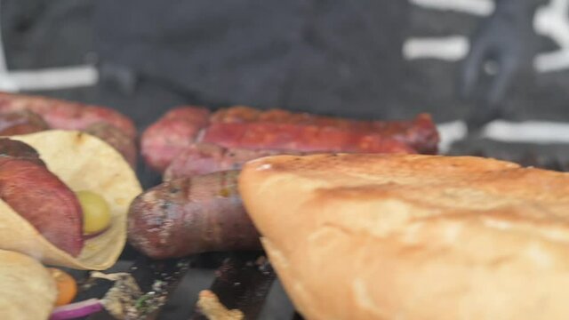 Grilled with rib of beef, chistorra and sausages. Golden sausages ready for the celebration of the picnic. Charcoal grill concept.