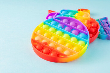 Colorful silicone sensory toys Poppit on blue background with copy space. Trendy play for fidget children